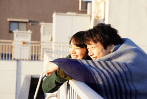 小松菜奈さんと坂口健太郎さんがベランダで毛布にくるまるシーンを撮影した写真